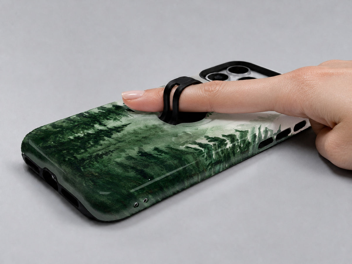Misty Evergreen Forest MagSafe Loop iPhone Case shown in use with a finger through the horizontal loop