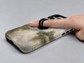 Misty Neutral Landscape MagSafe Loop iPhone Case shown in use with a finger through the horizontal loop