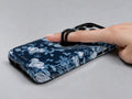 Navy Blue Rose Floral MagSafe Loop iPhone Case shown in use with a finger through the horizontal loop