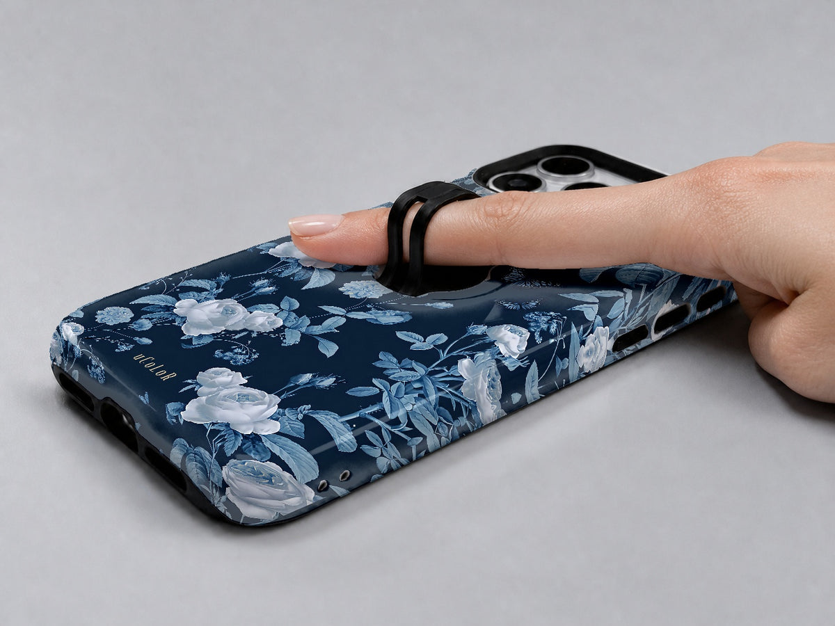 Navy Blue Rose Floral MagSafe Loop iPhone Case shown in use with a finger through the horizontal loop