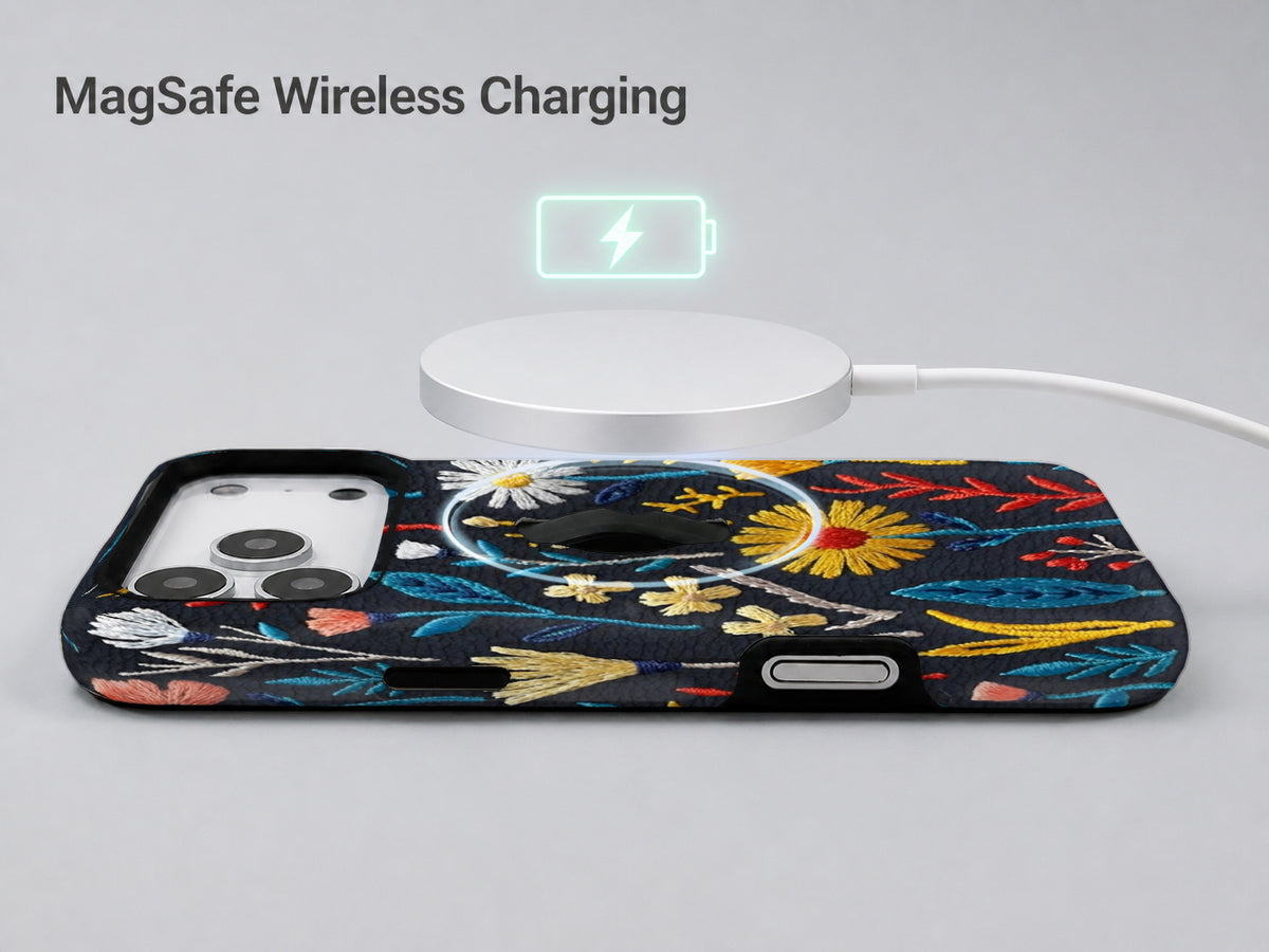 Navy Embroidered Wildflower MagSafe Loop iPhone Case shown with a MagSafe-compatible wireless charger attached