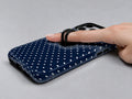 Navy Mini Polka Dot MagSafe Loop iPhone Case shown in use with a finger through the horizontal loop