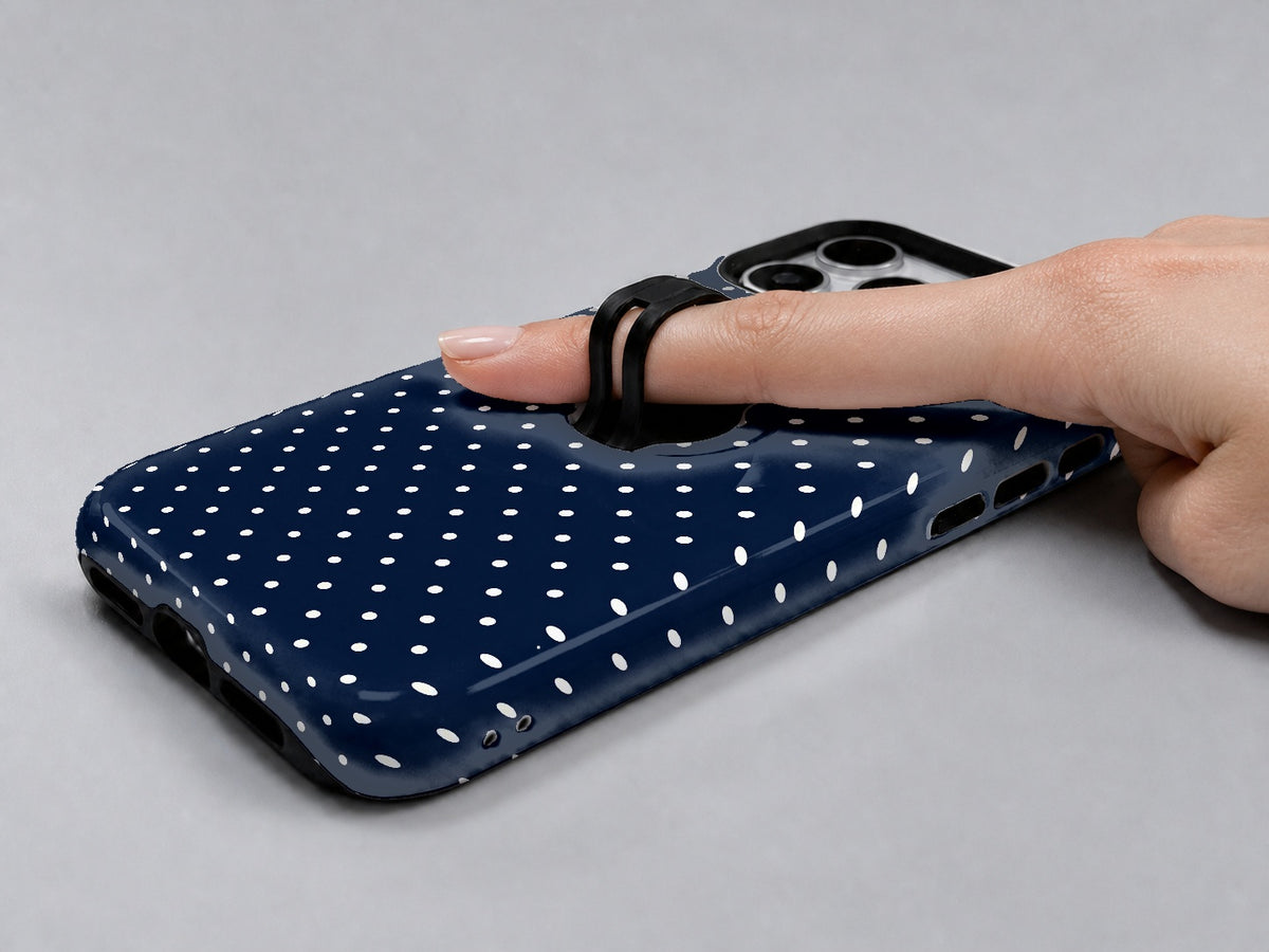 Navy Mini Polka Dot MagSafe Loop iPhone Case shown in use with a finger through the horizontal loop