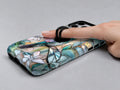 Pastel Butterfly Stained Glass MagSafe Loop iPhone Case shown in use with a finger through the horizontal loop