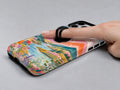 Pastel Painted Meadow Landscape MagSafe Loop iPhone Case shown in use with a finger through the horizontal loop