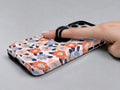 Peach Blue Abstract Leopard MagSafe Loop iPhone Case shown in use with a finger through the horizontal loop