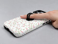 Pink Ditsy Floral MagSafe Loop iPhone Case shown in use with a finger through the horizontal loop