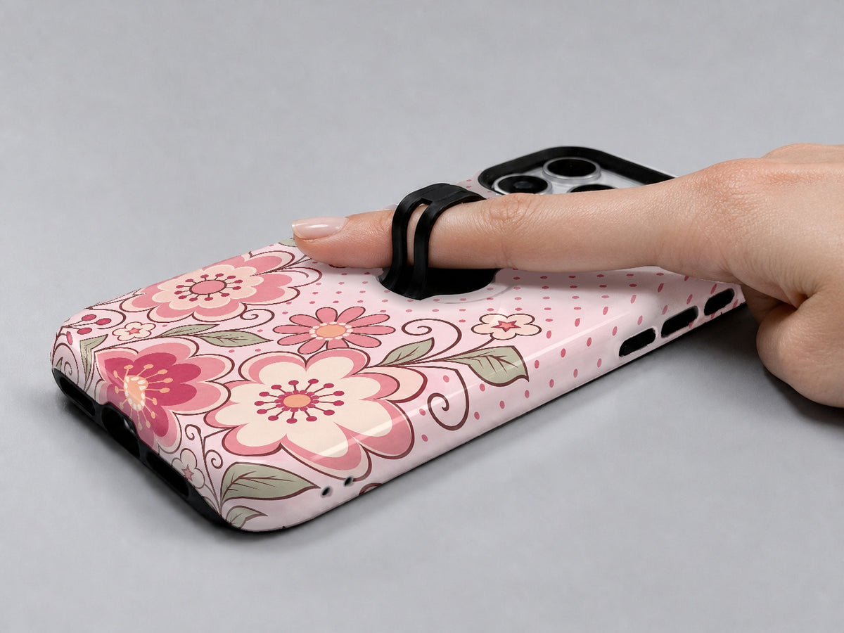Pink Retro Doodle Floral MagSafe Loop iPhone Case shown in use with a finger through the horizontal loop