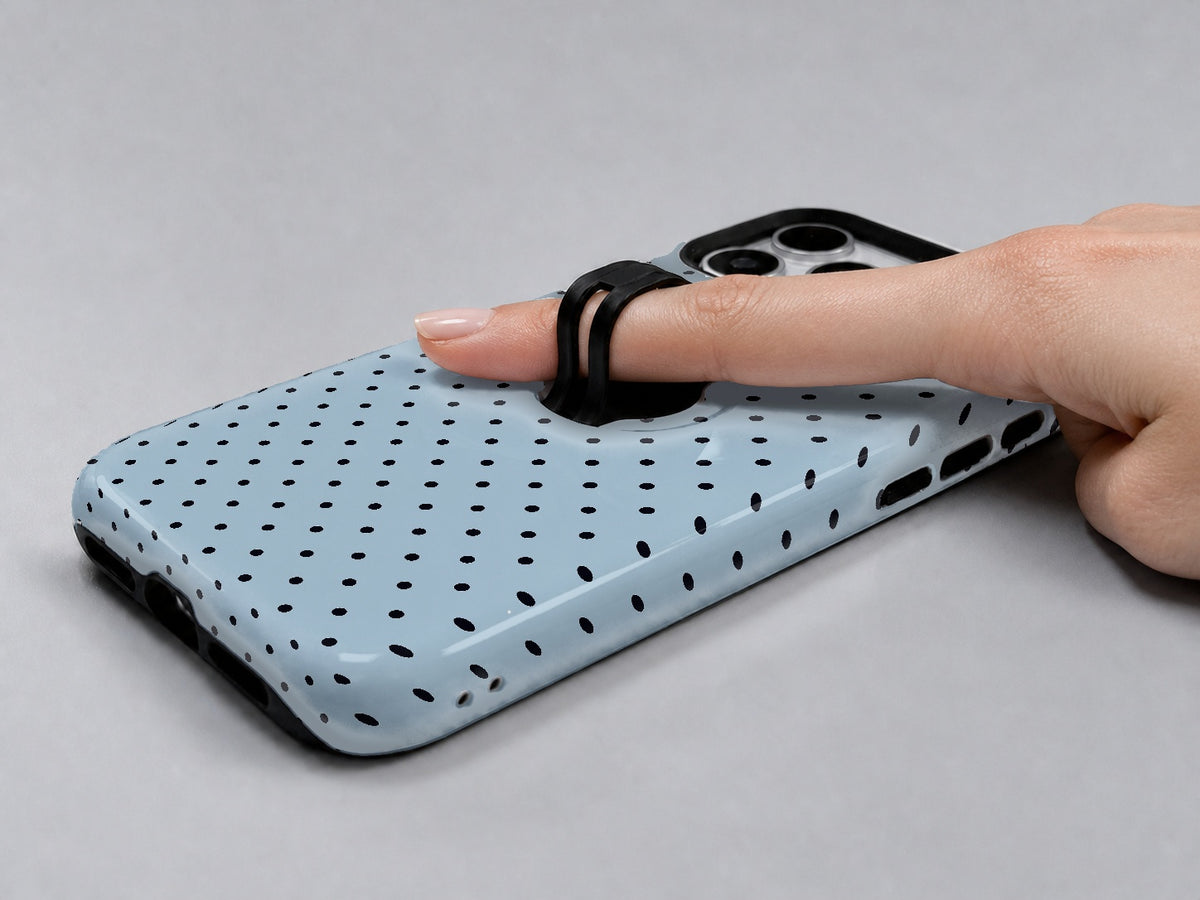 Powder Blue Mini Polka Dot MagSafe Loop iPhone Case shown in use with a finger through the horizontal loop