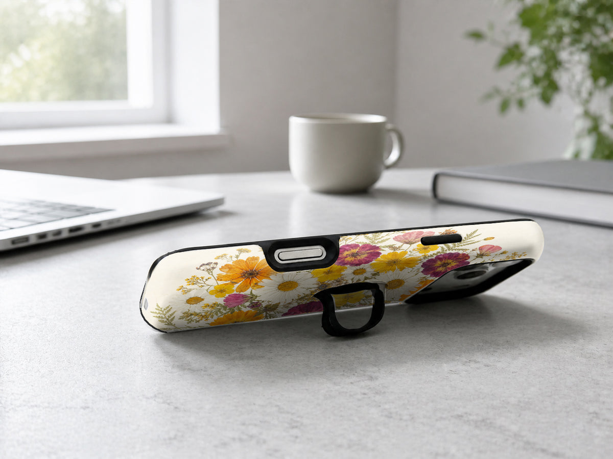 Pressed Daisy Wildflower Bouquet MagSafe Loop iPhone Case shown in a neutral white professional lifestyle setting