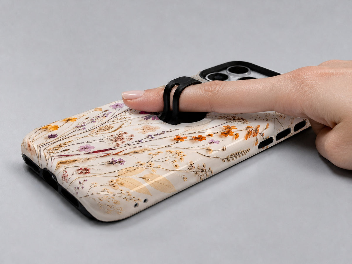 Pressed Wildflower Bouquet MagSafe Loop iPhone Case shown in use with a finger through the horizontal loop