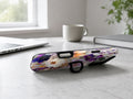 Purple Pressed Flower Garden MagSafe Loop iPhone Case shown in a neutral white professional lifestyle setting