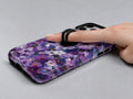 Purple Watercolor Flower Field MagSafe Loop iPhone Case shown in use with a finger through the horizontal loop