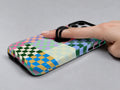 Rainbow Checkerboard Patchwork MagSafe Loop iPhone Case shown in use with a finger through the horizontal loop