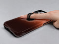 Rust Brown Ombre Gradient MagSafe Loop iPhone Case shown in use with a finger through the horizontal loop