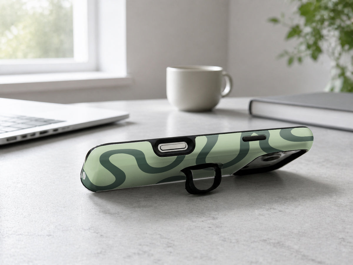 Sage Green Retro Swirl MagSafe Loop iPhone Case shown in a neutral white professional lifestyle setting