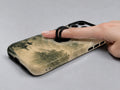 Sepia Mountain Pagoda MagSafe Loop iPhone Case shown in use with a finger through the horizontal loop