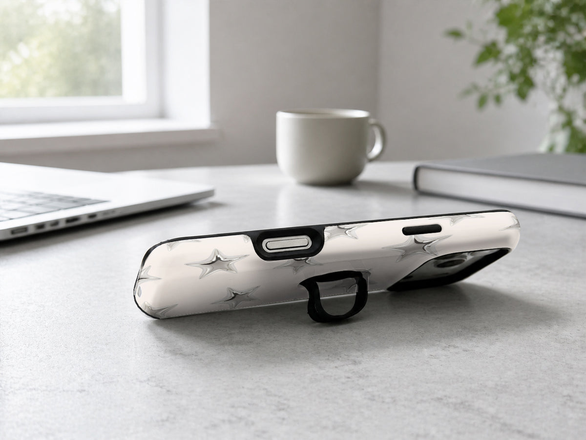 Silver Puffy Star MagSafe Loop iPhone Case shown in a neutral white professional lifestyle setting