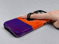 Tangerine Purple Color Block MagSafe Loop iPhone Case shown in use with a finger through the horizontal loop