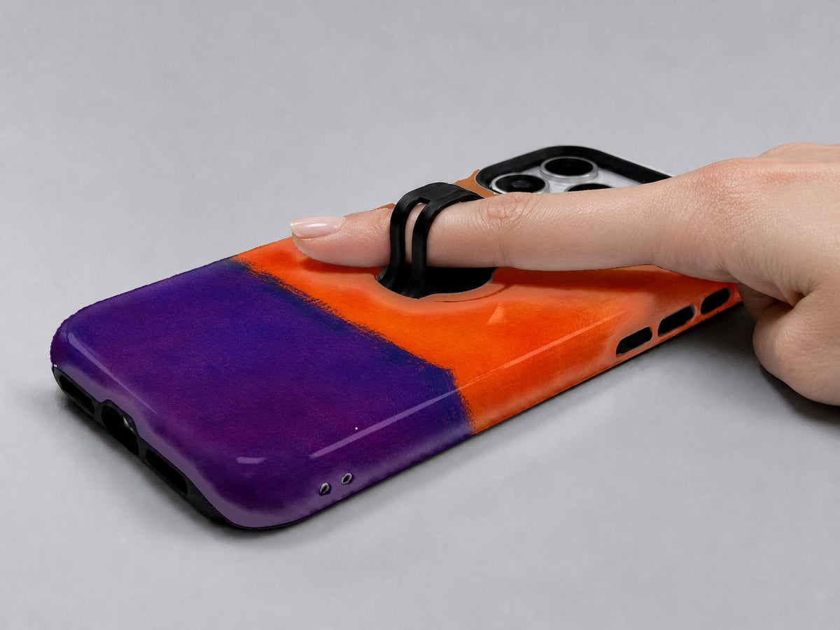Tangerine Purple Color Block MagSafe Loop iPhone Case shown in use with a finger through the horizontal loop