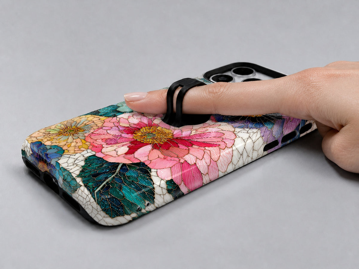 Teal Pink Stained Glass Floral MagSafe Loop iPhone Case shown in use with a finger through the horizontal loop