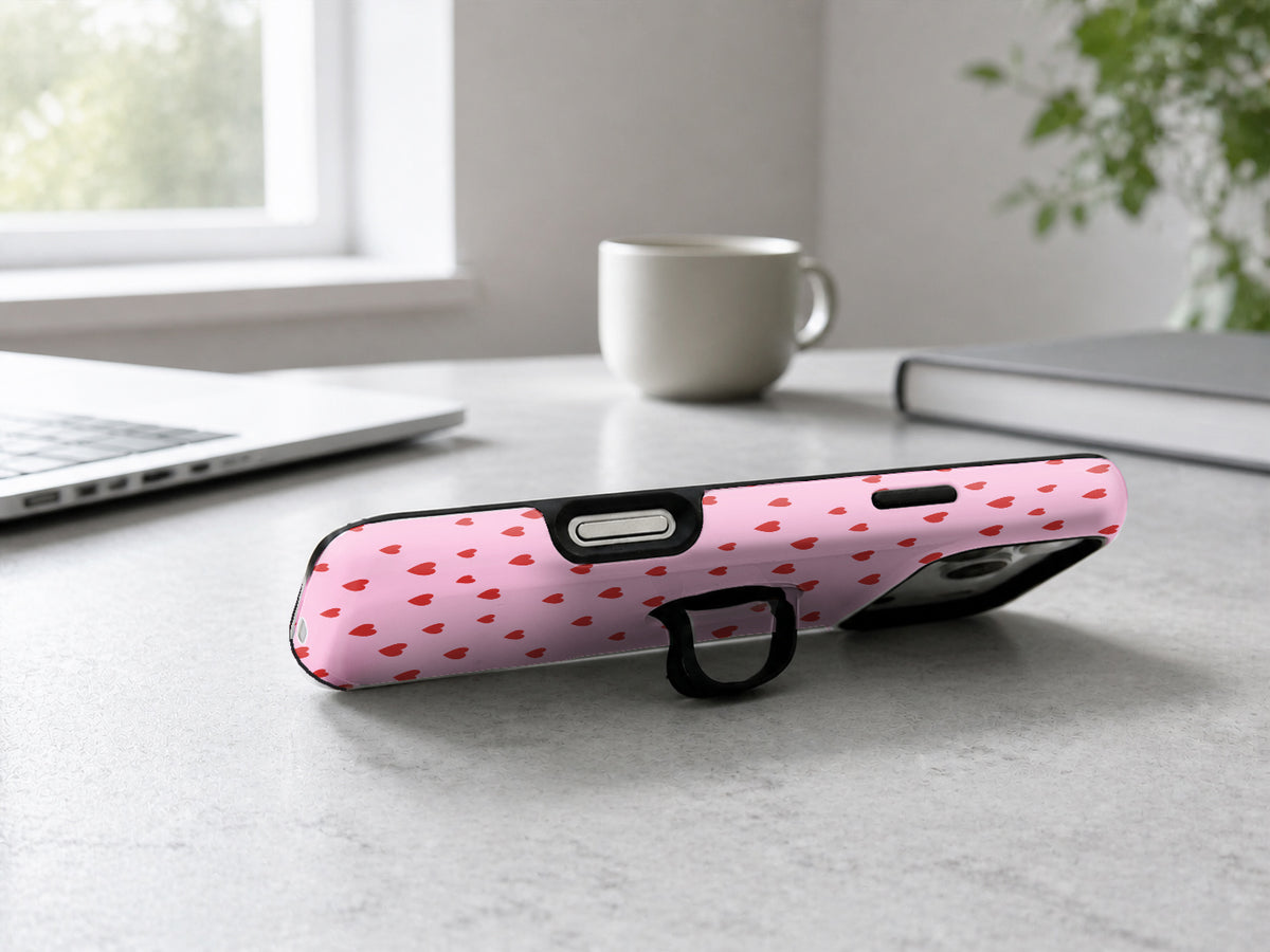 Tiny Red Hearts MagSafe Loop iPhone Case shown in a neutral white professional lifestyle setting