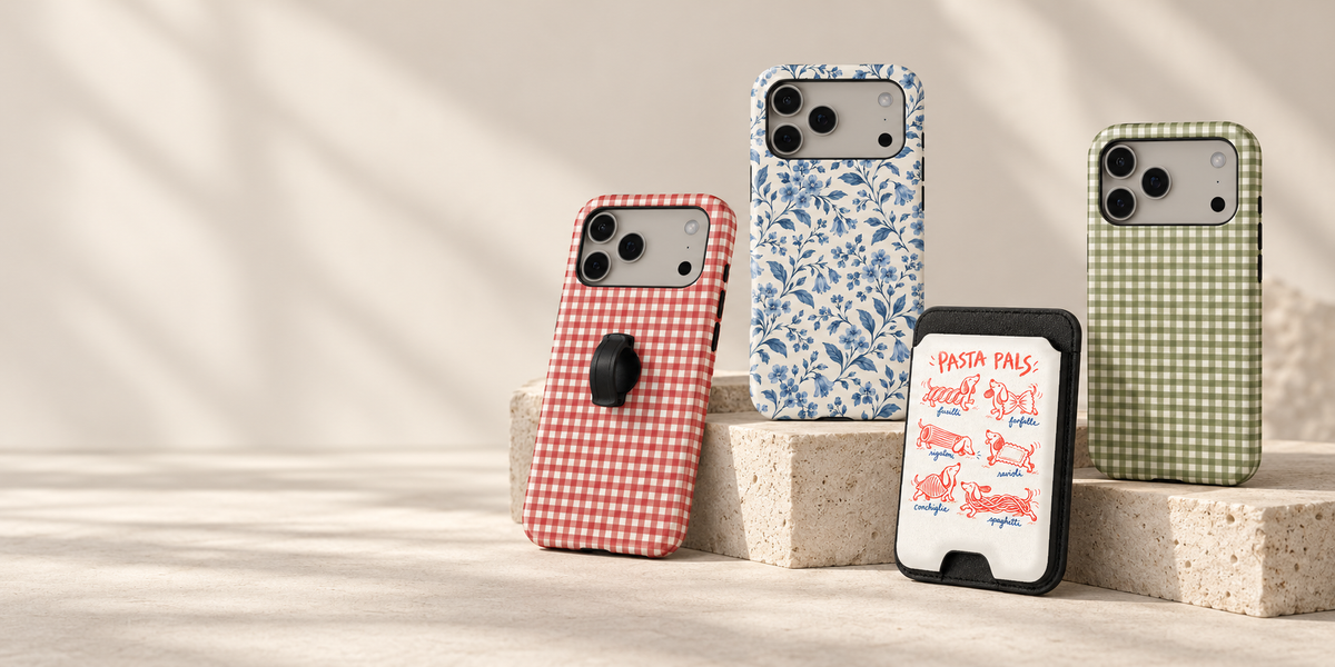 Blue botanical, cherry gingham and olive gingham phone cases with a Pasta Pals card holder, styled on pale stone plinths.