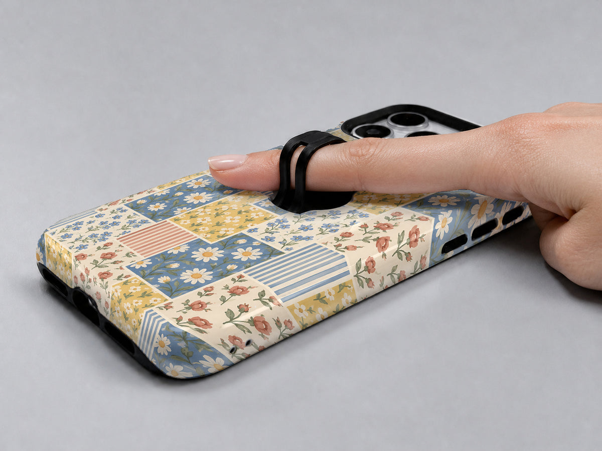 Blue and Yellow Daisy Floral Patchwork MagSafe Loop Case, shown with a finger through the loop