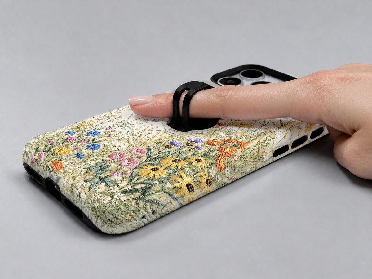 Vintage Wildflower Meadow MagSafe Loop iPhone Case shown in use with a finger through the horizontal loop