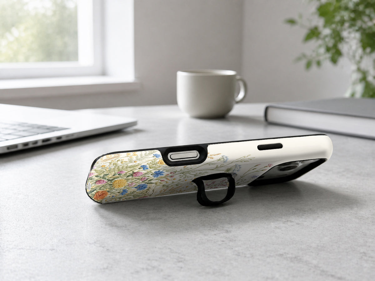 Vintage Wildflower Meadow MagSafe Loop iPhone Case shown in a neutral white professional lifestyle setting
