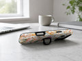 Warm Wildflower Stained Glass MagSafe Loop iPhone Case shown in a neutral white professional lifestyle setting