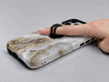 White Gold Agate Marble MagSafe Loop iPhone Case shown in use with a finger through the horizontal loop